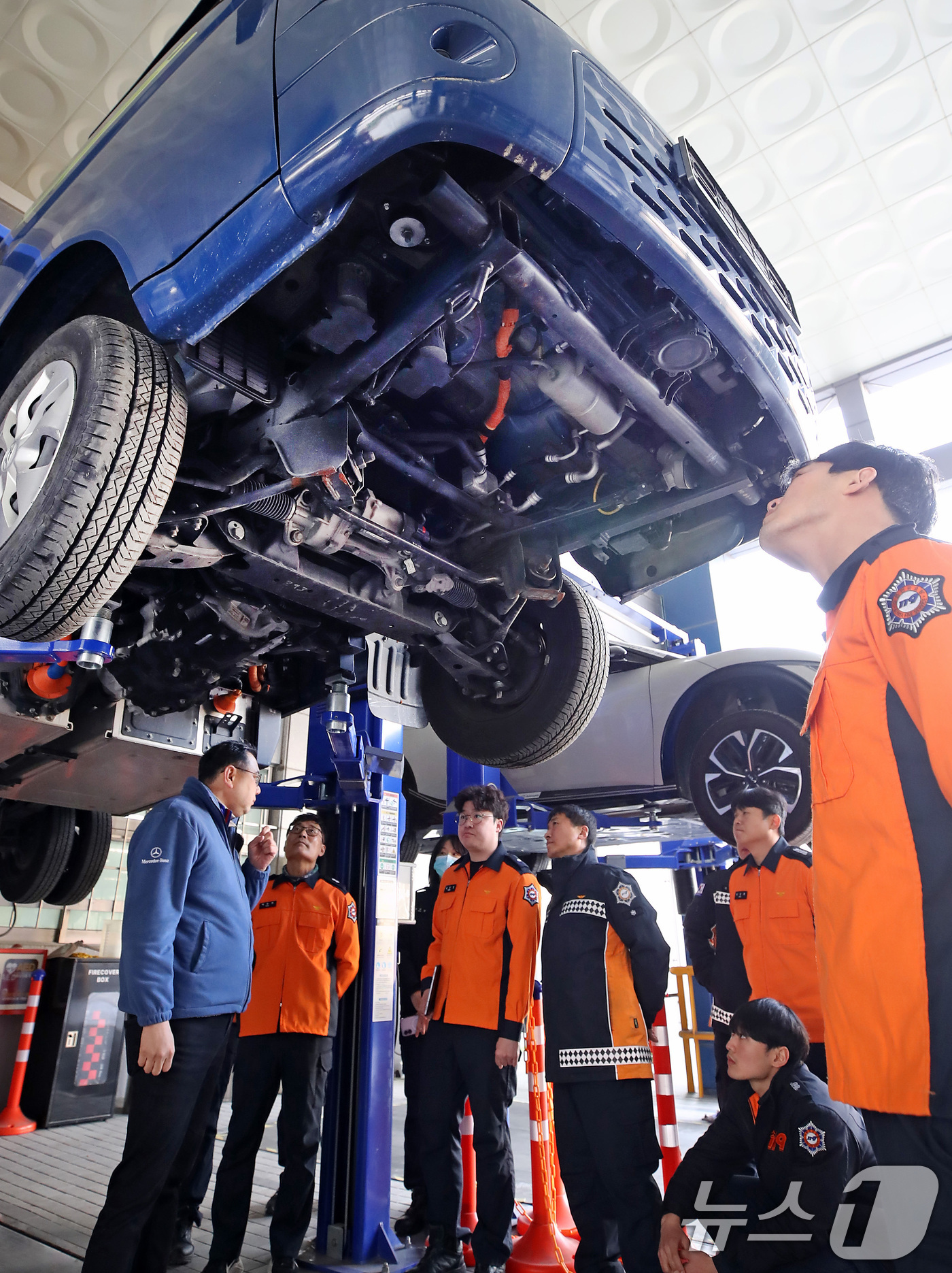 (대구=뉴스1) 공정식 기자 = 15일 대구 남구 영남이공대 스마트 e-자동차과 실습실에서 열린 '대구소방안전본부 전기자동차 화재진압 역량 강화 교육'에 참가한 소방관들이 전기차를 …