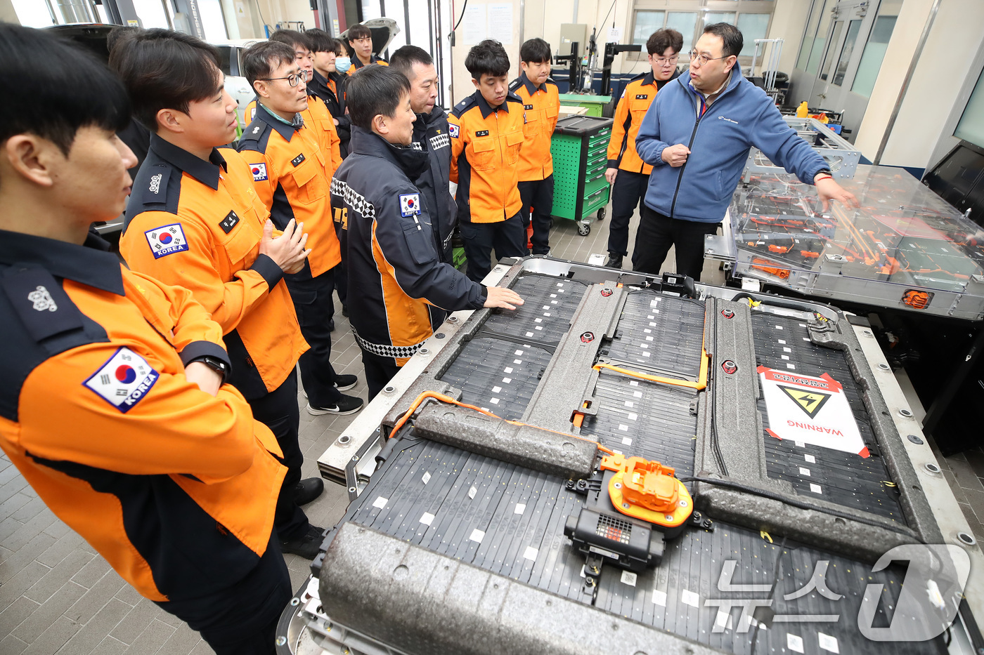 (대구=뉴스1) 공정식 기자 = 15일 대구 남구 영남이공대 스마트 e-자동차과 실습실에서 열린 '대구소방안전본부 전기자동차 화재진압 역량 강화 교육'에 참가한 소방관들이 전기차를 …