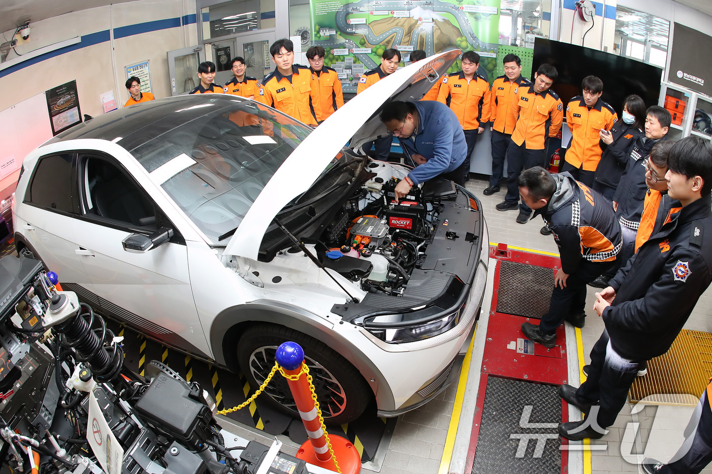 (대구=뉴스1) 공정식 기자 = 15일 대구 남구 영남이공대 스마트 e-자동차과 실습실에서 열린 '대구소방안전본부 전기자동차 화재진압 역량 강화 교육'에 참가한 소방관들이 전기차를 …