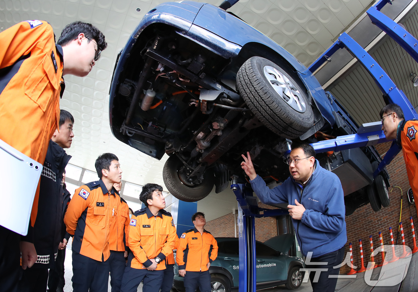 (대구=뉴스1) 공정식 기자 = 15일 대구 남구 영남이공대 스마트 e-자동차과 실습실에서 열린 '대구소방안전본부 전기자동차 화재진압 역량 강화 교육'에 참가한 소방관들이 전기차를 …