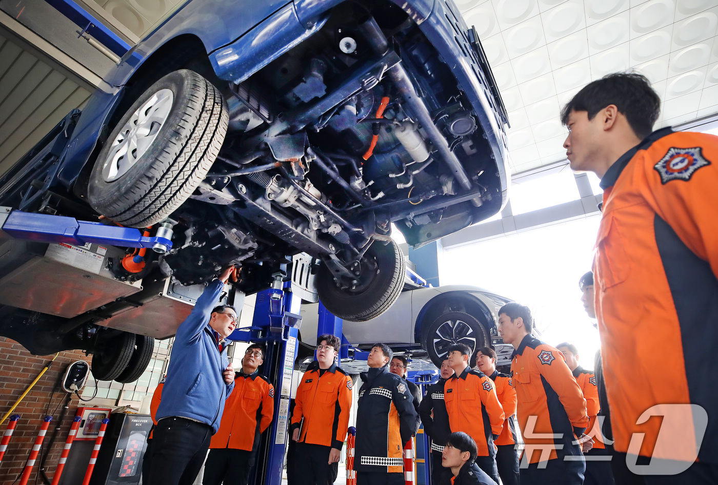 (대구=뉴스1) 공정식 기자 = 15일 대구 남구 영남이공대 스마트 e-자동차과 실습실에서 열린 '대구소방안전본부 전기자동차 화재진압 역량 강화 교육'에 참가한 소방관들이 전기차를 …
