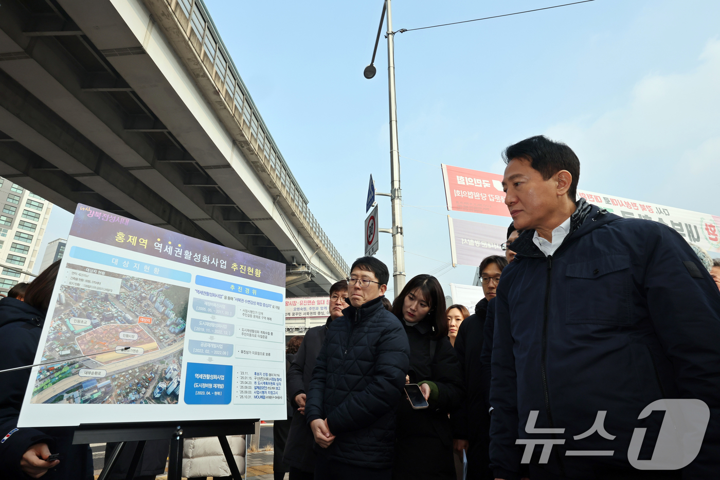 (서울=뉴스1) 황기선 기자 = 오세훈 서울시장이 15일 오후 서울 서대문구 홍은사거리에서 홍제천 일대 내부순환로 현장을 둘러본 후 관계자에게 브리핑을 받고 있다.오 시장은 지난해 …