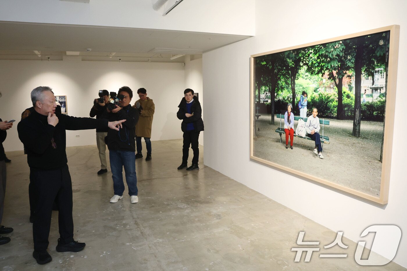 본문 이미지 - 박용만 전 두산회장이 15일 오후 서울 중구 피크닉 전시관에서 열린 자신의 사진전 '휴먼 모먼트' 기자간담회에 앞서 참석자들에게 전시 작품에 대해 설명하고 있다. 2026.1.15/뉴스1 ⓒ News1 이광호 기자