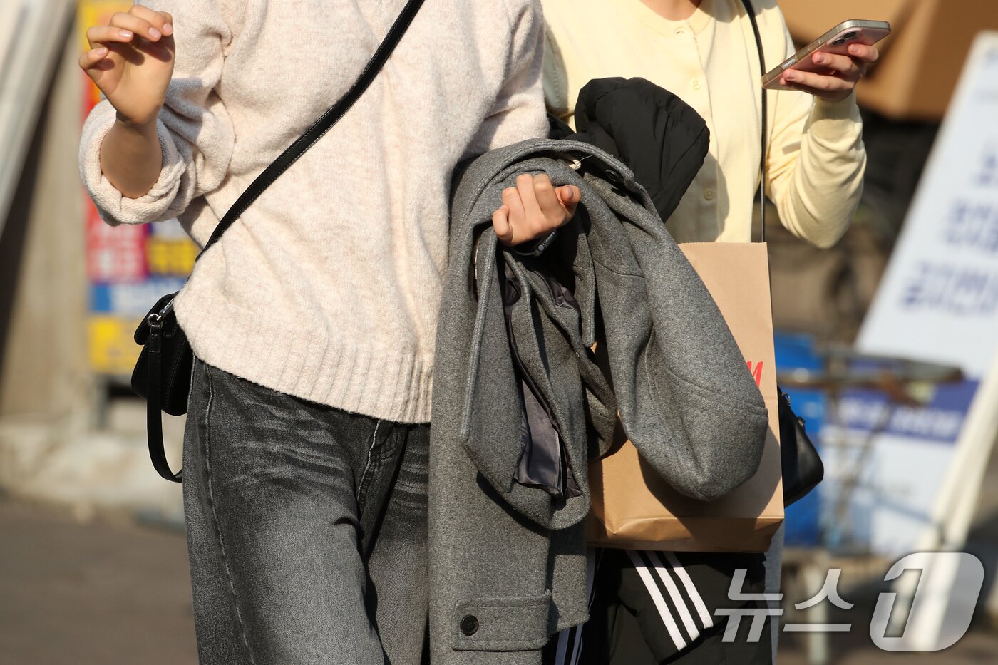 본문 이미지 - 하루 사이 기온이 크게 오른 15일 오후 대구 중구 동성로에서 외투를 벗어 손에 든 시민들이 걸어가고 있다. 2026.1.15/뉴스1 ⓒ News1 공정식 기자