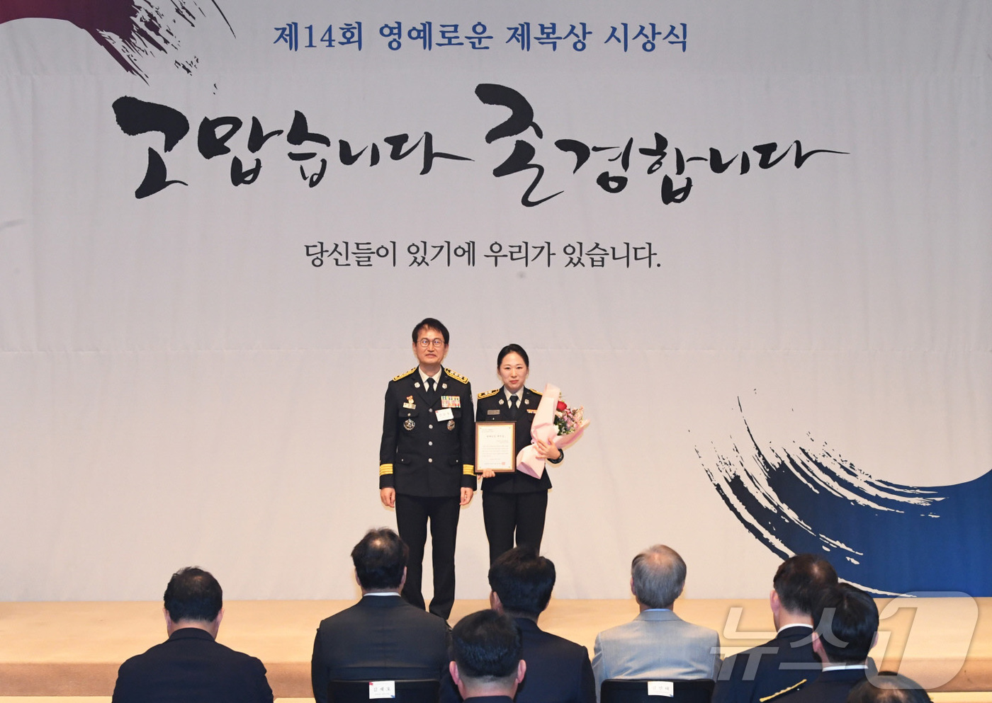 (서울=뉴스1) = 김승룡 소방청장 직무대행이 15일 서울 중구 한국프레스센터에서 열린 '제14회 영예로운 제복상 시상식'에서 제복상 수상자인 소방청 이주희 소방경에게 상패를 수여 …