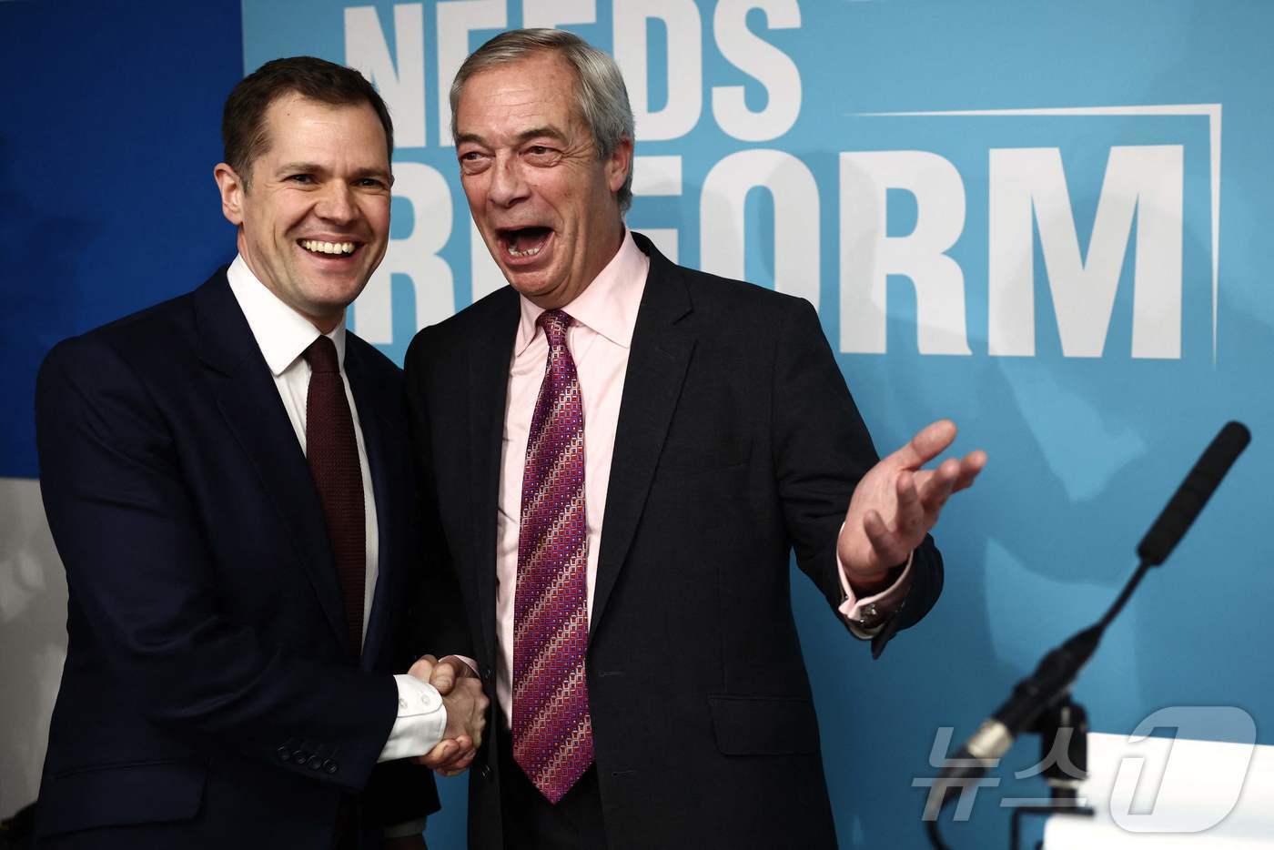 본문 이미지 - 영국 보수당 예비 법무장관이었던 로버트 젠릭(왼쪽) 의원이 15일(현지시간) 나이절 패라지 영국개혁당 대표와 악수하고 있다. 2025.01.15. ⓒ AFP=뉴스1 ⓒ News1 이정환 기자