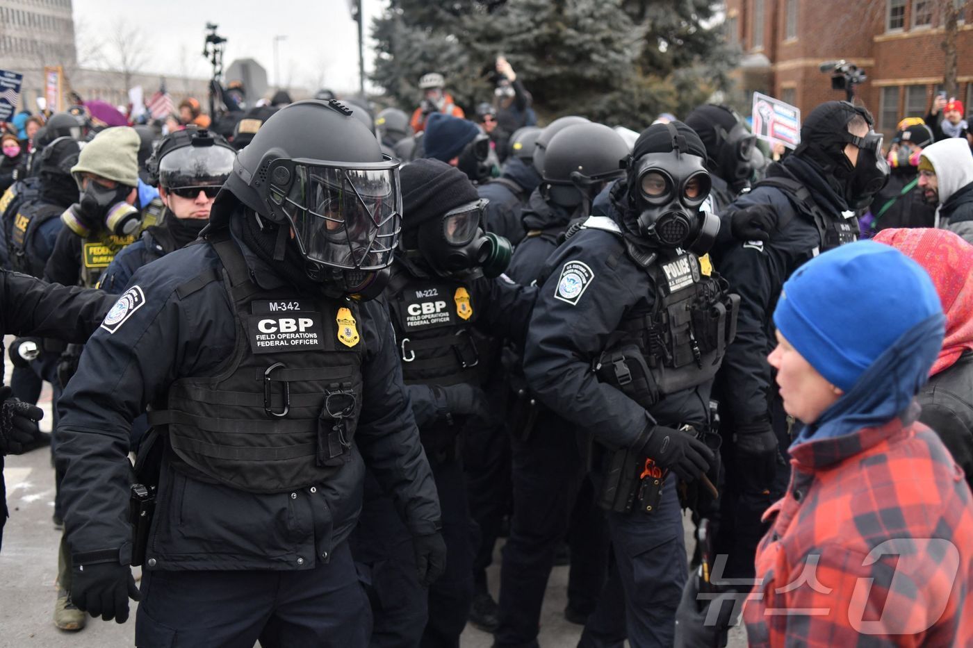 본문 이미지 - 15일(현지시간) 미국 미네소타주 미니애폴리스에서 세관국경보호국(CBP) 요원들이 이민세관단속국(ICE) 반대 집회 중인 시위대와 대치하고 있다. 2026.01.15. ⓒ AFP=뉴스1 ⓒ News1 윤다정 기자