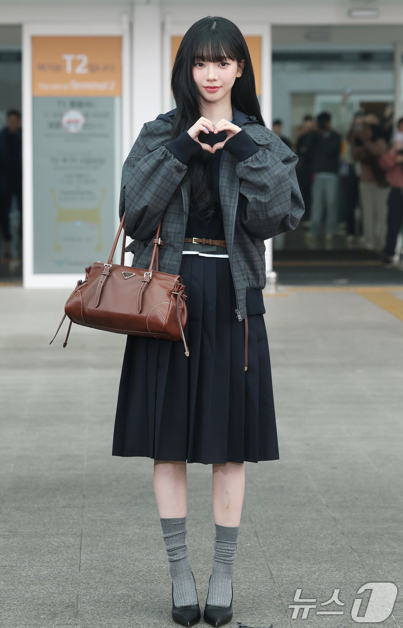 본문 이미지 - 에스파 카리나가 해외 일정을 위해 16일 인천국제공항을 통해 밀라노로 출국하기 전 하트 포즈를 취하고 있다. ⓒ News1 권현진 기자