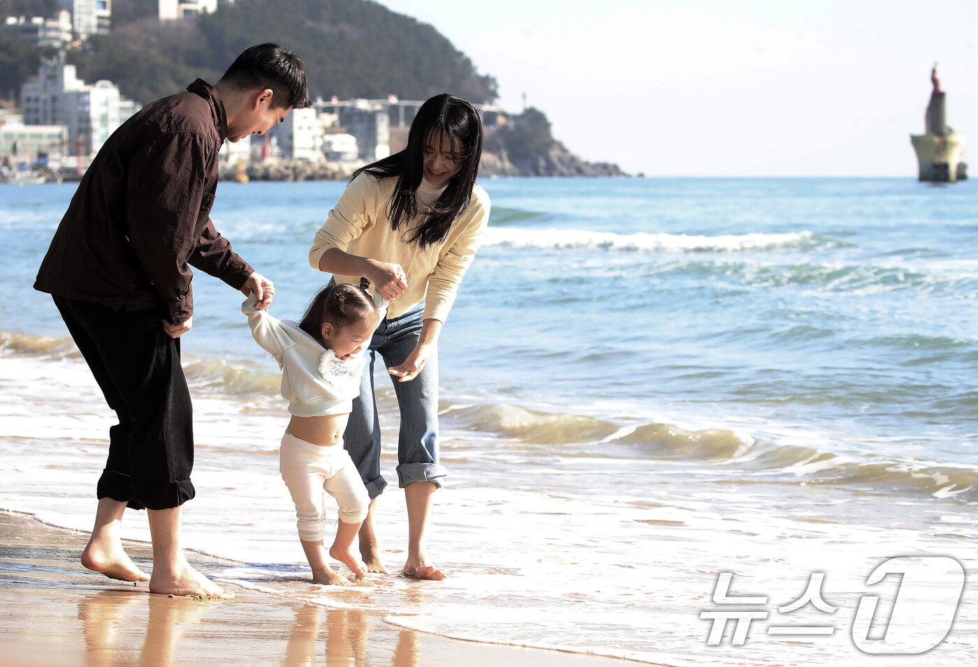 본문 이미지 - 포근한 날씨를 보인 16일 부산 해운대해수욕장에서 가벼운 복장 차림을 한 가족이 바닷물에 발을 담그며 즐거운 시간을 보내고 있다. 2026.1.16/뉴스1 ⓒ News1 윤일지 기자