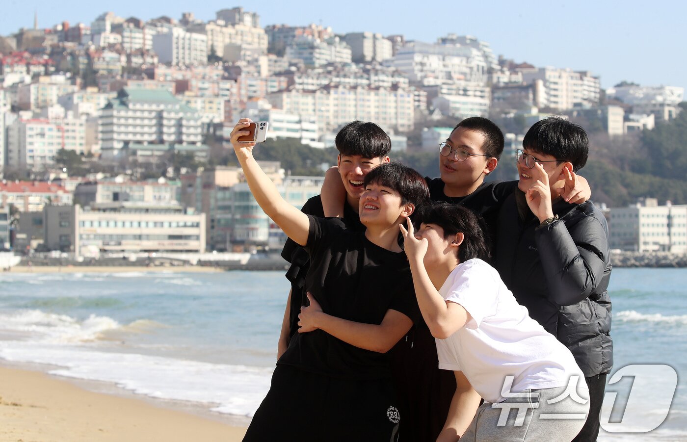 본문 이미지 - 포근한 날씨를 보인 16일 부산 해운대해수욕장에서 반팔 차림을 한 시민들이 셀카를 찍으며 추억을 남기고 있다. 2026.1.16/뉴스1 ⓒ News1 윤일지 기자
