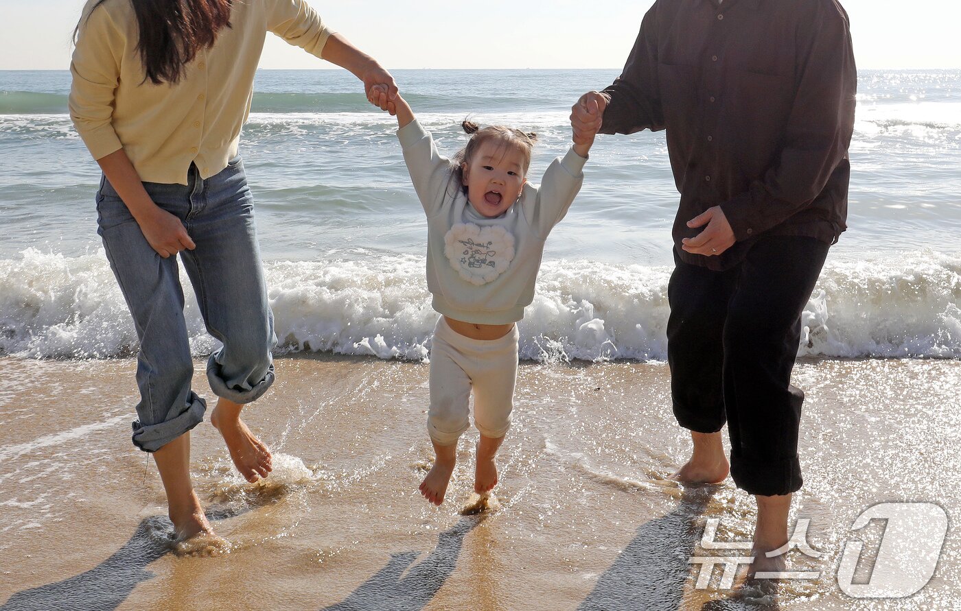 본문 이미지 - 포근한 날씨를 보인 16일 부산 해운대해수욕장에서 가벼운 복장 차림을 한 가족이 바닷물에 발을 담그며 즐거운 시간을 보내고 있다. 2026.1.16/뉴스1 ⓒ News1 윤일지 기자