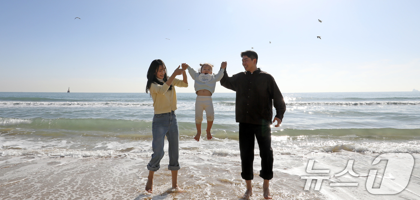 (부산=뉴스1) 윤일지 기자 = 포근한 날씨를 보인 16일 부산 해운대해수욕장에서 가벼운 복장 차림을 한 가족이 바닷물에 발을 담그며 즐거운 시간을 보내고 있다. 2026.1.16 …