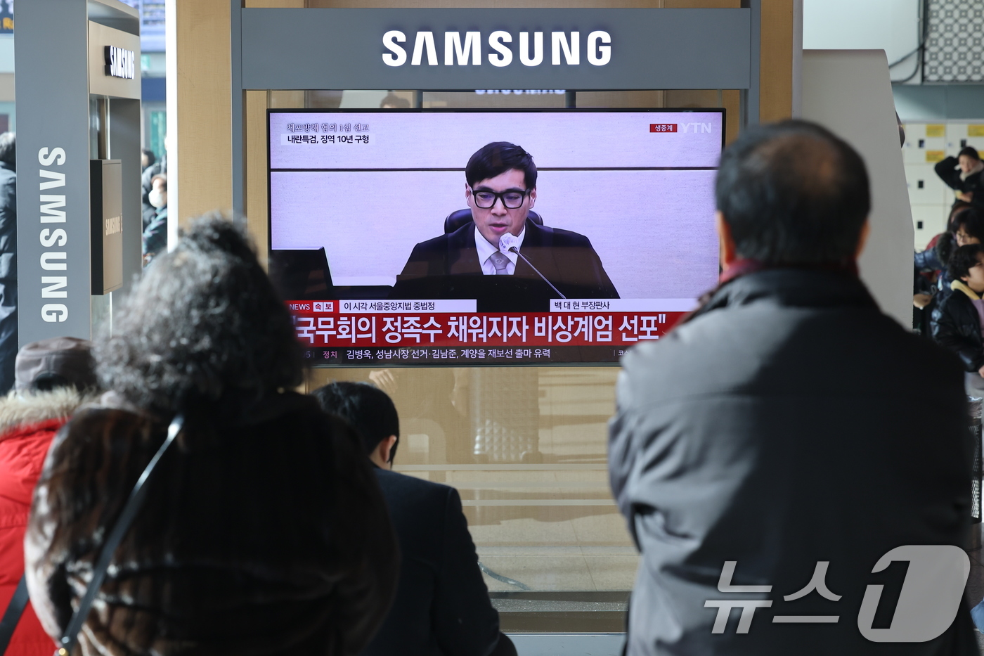 (서울=뉴스1) 이광호 기자 = 16일 오후 서울역에서 시민들이 체포 방해와 국무위원 심의권 침해 등 혐의로 기소된 윤석열 전 대통령에 대한 1심 선고 생중계를 지켜보고 있다. 서 …