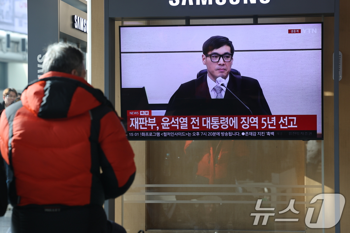 (서울=뉴스1) 이광호 기자 = 16일 오후 서울역에서 시민들이 체포 방해와 국무위원 심의권 침해 등 혐의로 기소된 윤석열 전 대통령에 대한 1심 선고 생중계를 지켜보고 있다. 서 …