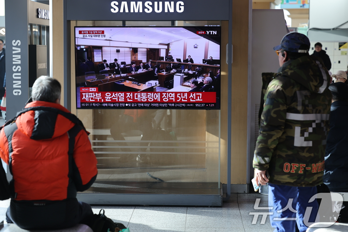 (서울=뉴스1) 이광호 기자 = 16일 오후 서울역에서 시민들이 체포 방해와 국무위원 심의권 침해 등 혐의로 기소된 윤석열 전 대통령에 대한 1심 선고 생중계를 지켜보고 있다. 서 …
