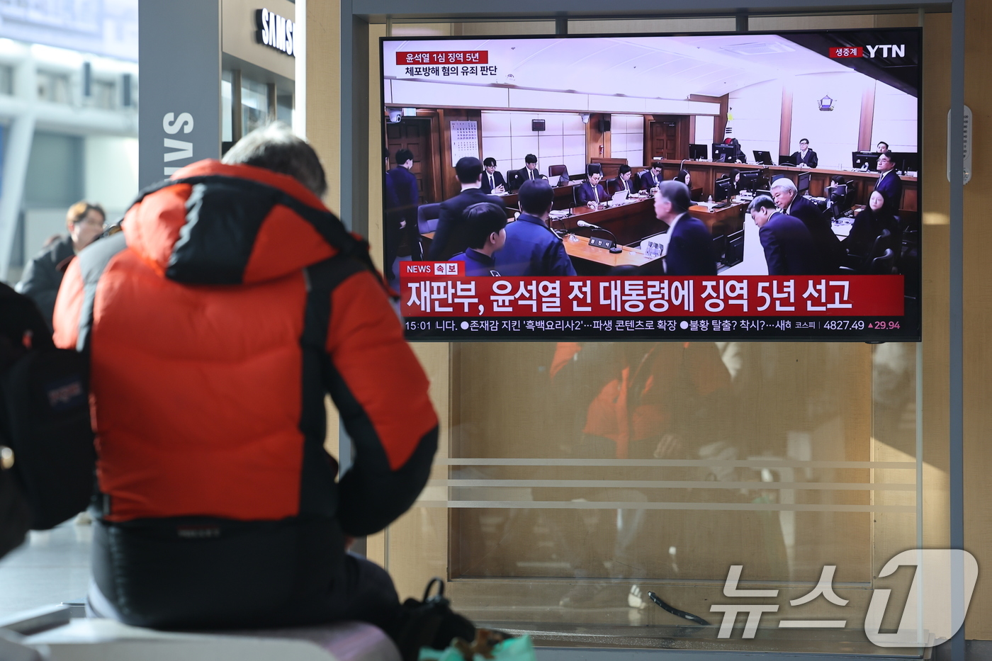 (서울=뉴스1) 이광호 기자 = 16일 오후 서울역에서 시민들이 체포 방해와 국무위원 심의권 침해 등 혐의로 기소된 윤석열 전 대통령에 대한 1심 선고 생중계를 지켜보고 있다. 서 …