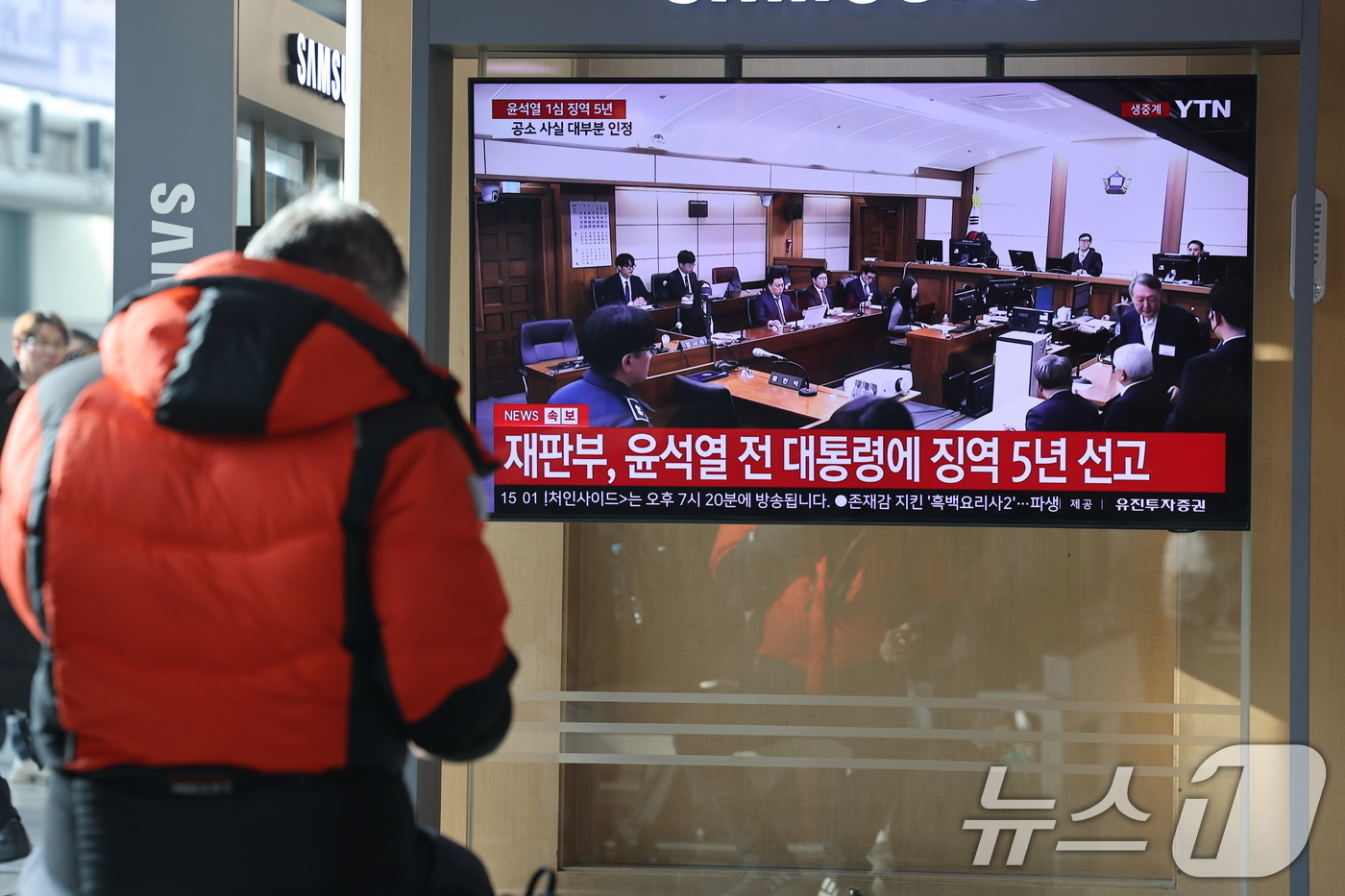 (서울=뉴스1) 이광호 기자 = 16일 오후 서울역에서 시민들이 체포 방해와 국무위원 심의권 침해 등 혐의로 기소된 윤석열 전 대통령에 대한 1심 선고 생중계를 지켜보고 있다. 서 …