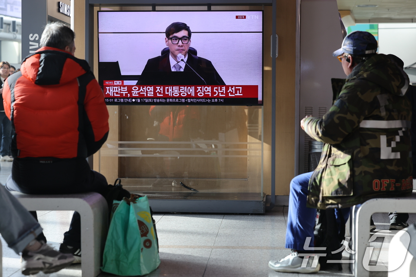 (서울=뉴스1) 이광호 기자 = 16일 오후 서울역에서 시민들이 체포 방해와 국무위원 심의권 침해 등 혐의로 기소된 윤석열 전 대통령에 대한 1심 선고 생중계를 지켜보고 있다. 서 …