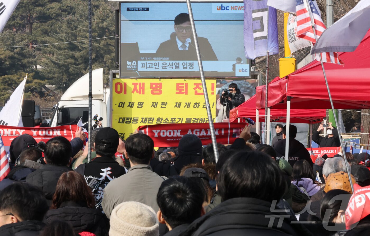 본문 이미지 - 윤석열 전 대통령의 고위공직자범죄수사처(공수처) 체포영장 집행 방해 및 국무위원 심의권 침해 혐의 1심 선고 재판이 열린 16일 오후 서울 서초구 서울중앙지법 앞에서 윤 전 대통령 지지자들이 TV를 통해 생중계를 지켜보고 있다. 2026.1.16/뉴스1 ⓒ News1 김진환 기자