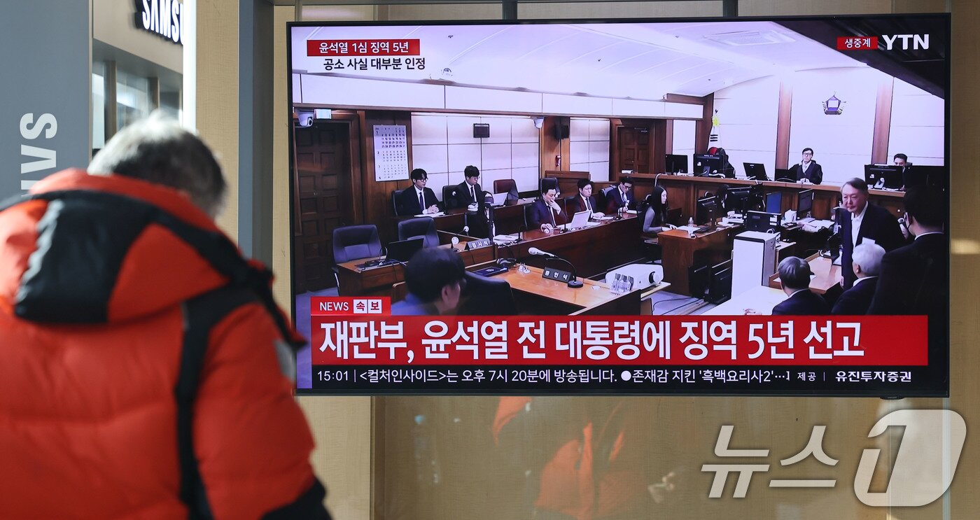 본문 이미지 - 16일 오후 서울역에서 시민들이 체포 방해와 국무위원 심의권 침해 등 혐의로 기소된 윤석열 전 대통령에 대한 1심 선고 생중계를 지켜보고 있다. 2026.1.16/뉴스1 ⓒ News1 이광호 기자