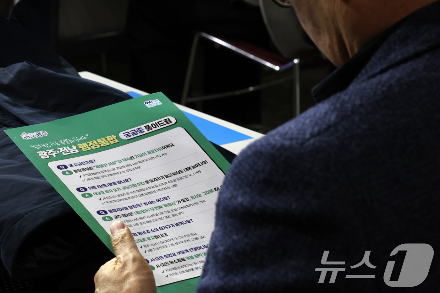 (광주=뉴스1) 박지현 기자 = 16일 오후 광주 서구 김대중컴벤션센터에서 '광주전남 행정통합 추진 시도민협의회' 발대식에서 한 시민이 안내문을 읽고 있다. 2026.1.16/뉴스 …