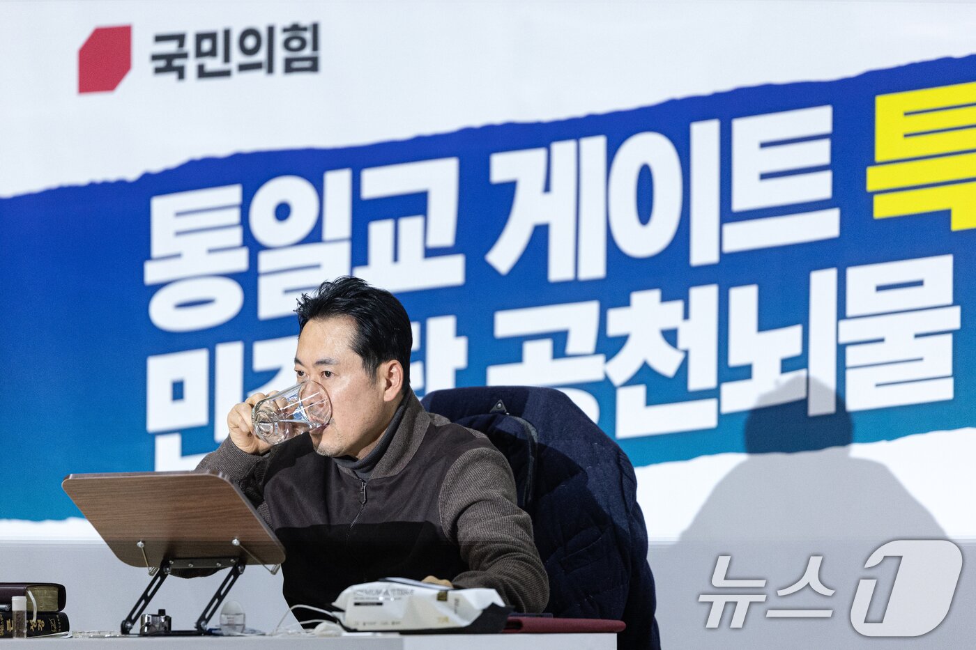 본문 이미지 - 더불어민주당의 통일교 및 공천뇌물 특검 수용을 촉구하며 4일째 단식을 이어가고 있는 장동혁 국민의힘 대표가 18일 서울 여의도 국회 로텐더홀에서 목을 축이고 있다. 2026.1.18/뉴스1 ⓒ News1 이승배 기자