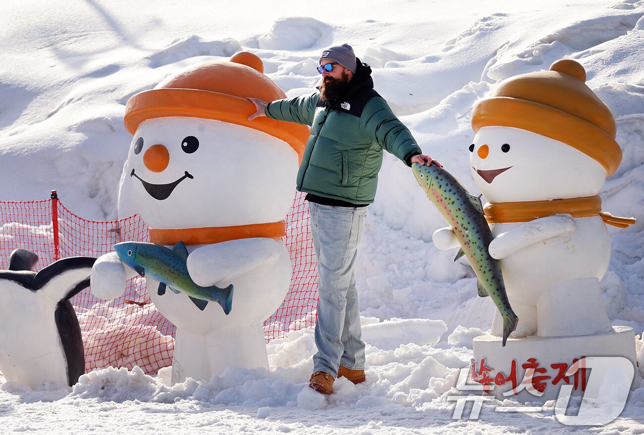 본문 이미지 - 18일 강원도 평창군 진부면 오대천 일원에 열린 평창송어축제를 찾은 외국인 방문객이 눈동이 조각을 배경으로 기념사진을 촬영하고 있다. (평창군 제공. 재판매 및 DB 금지) 2026.1.18/뉴스1