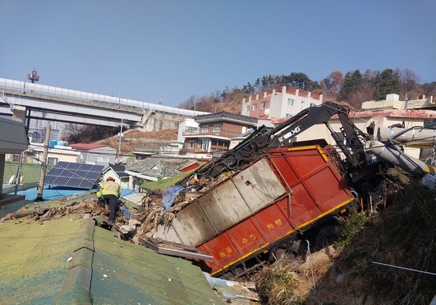 재활용품 수거차량 주택 지붕에 '추락'…내리막길서 도로 이탈