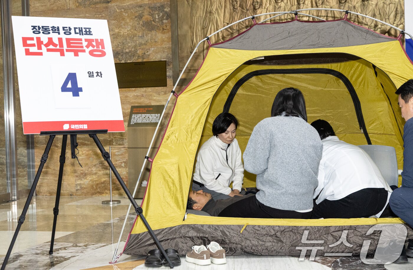 본문 이미지 - 더불어민주당의 통일교 및 공천뇌물 특검 수용을 촉구하며 4일째 단식을 이어가고 있는 장동혁 국민의힘 대표가 18일 서울 여의도 국회 로텐더홀에서 의료진에게 건강 상태를 확인 받고 있다. 2026.1.18/뉴스1 ⓒ News1 이승배 기자