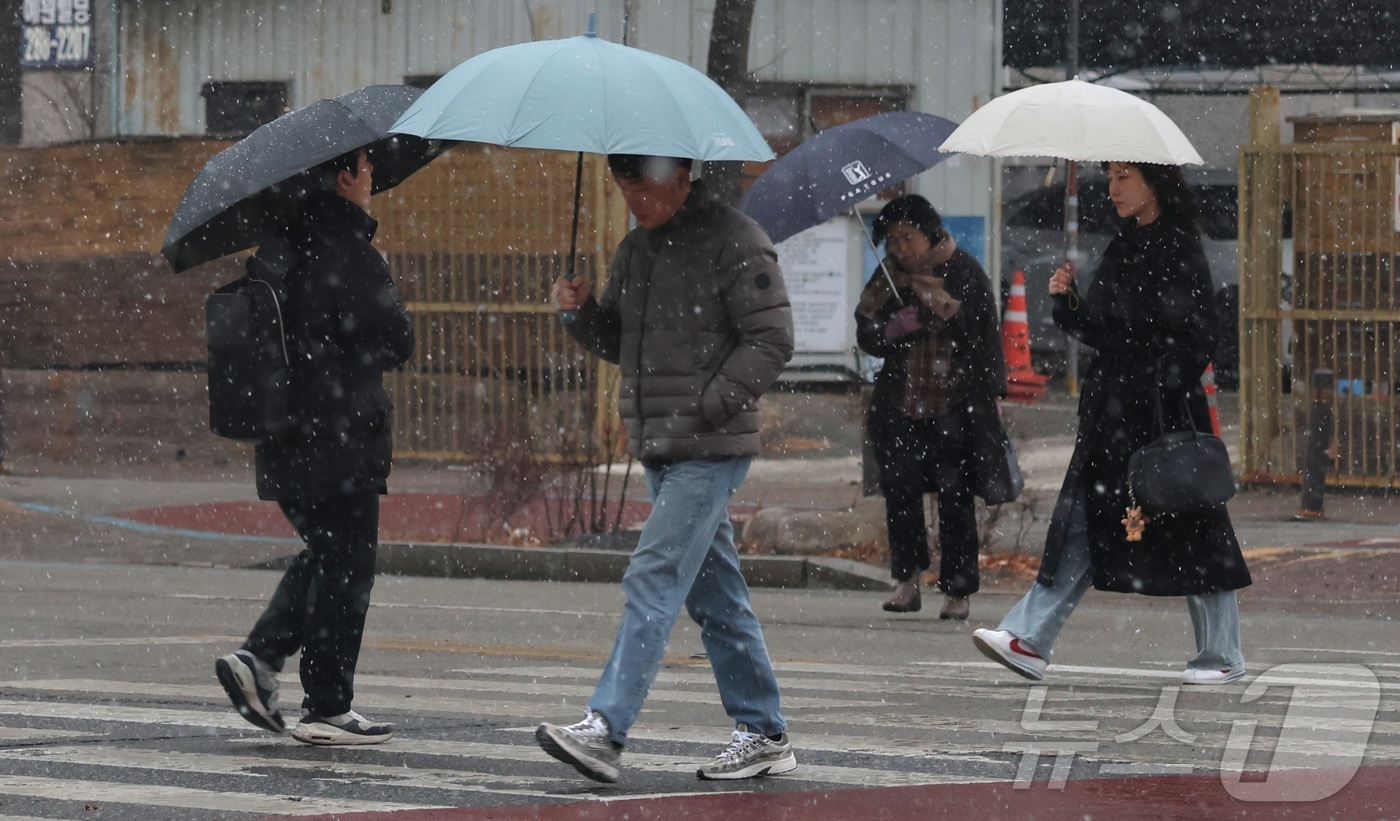 (전주=뉴스1) 유경석 기자 = 진눈깨비가 내린 19일 전북 전주시 기린대로에서 우산을 쓴 시민들이 발걸음을 옮기고 있다. 2026.1.19/뉴스1
