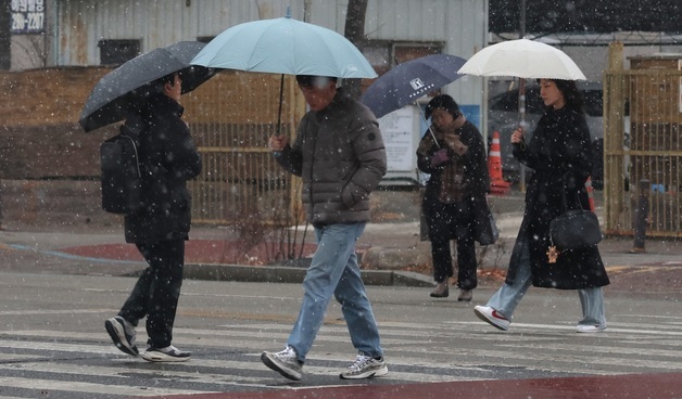진눈깨비에 우산 쓴 시민들