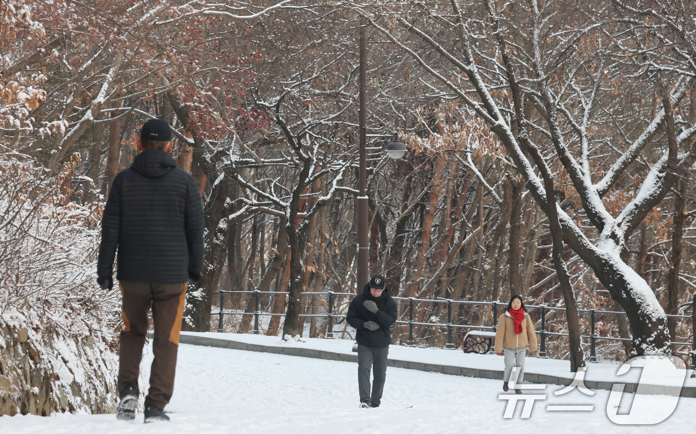 (수원=뉴스1) 김영운 기자 = 간밤에 눈이 내린 19일 경기 수원시 팔달구 팔달산 산책로에서 시민들이 산책을 하고 있다. 2026.1.19/뉴스1