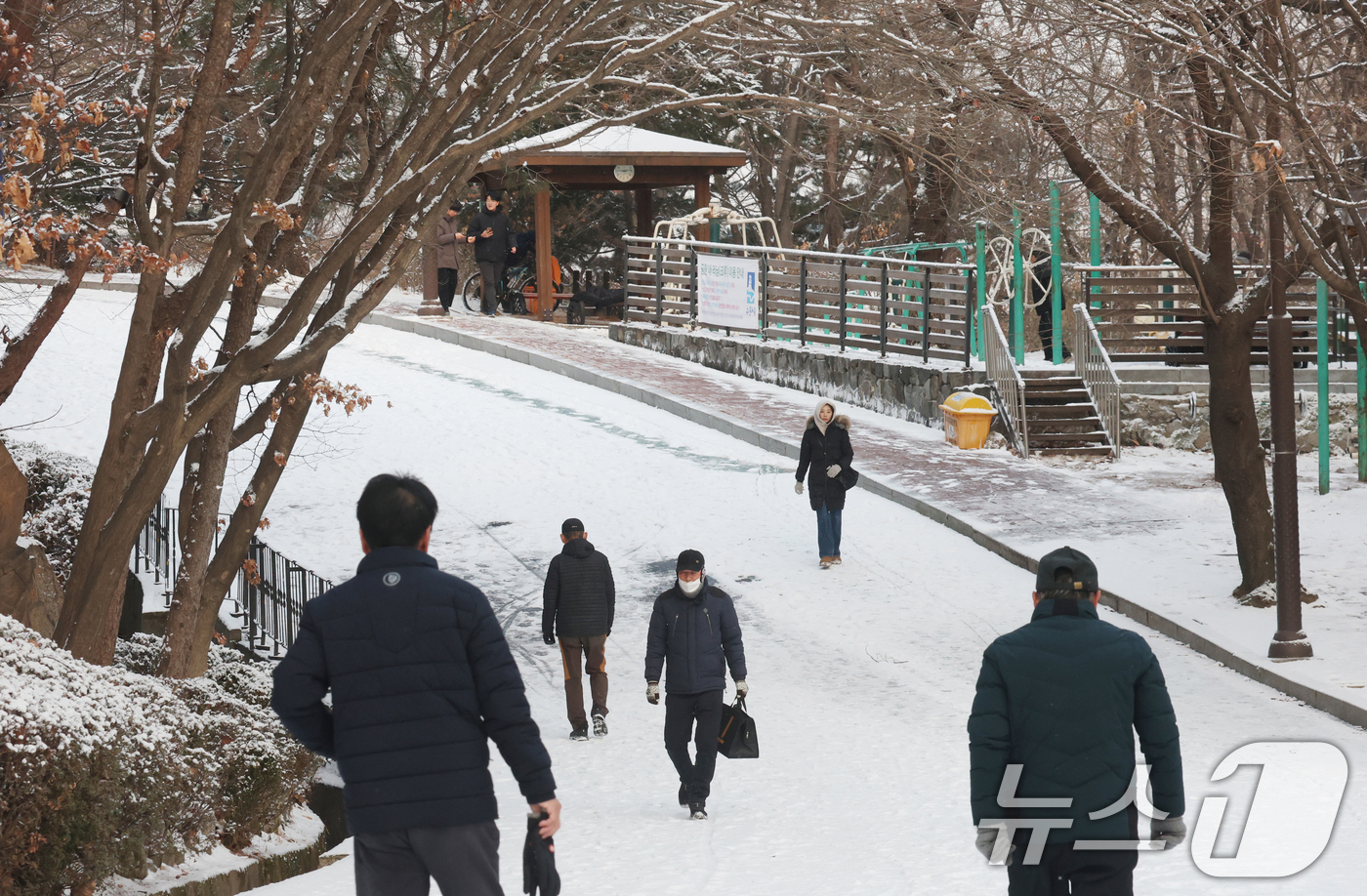 (수원=뉴스1) 김영운 기자 = 간밤에 눈이 내린 19일 경기 수원시 팔달구 팔달산 산책로에서 시민들이 산책을 하고 있다. 2026.1.19/뉴스1