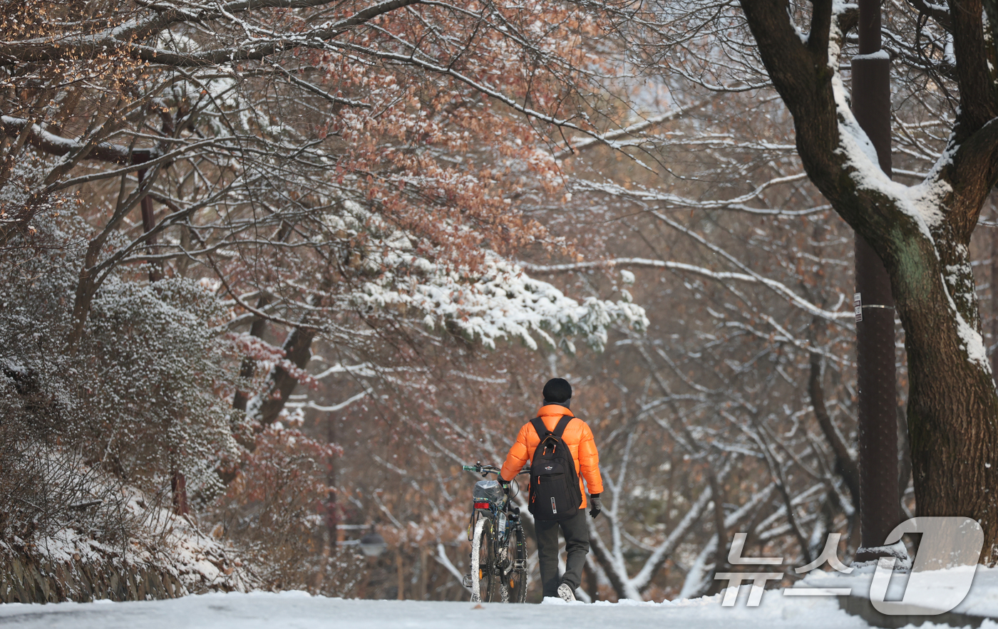 (수원=뉴스1) 김영운 기자 = 간밤에 눈이 내린 19일 경기 수원시 팔달구 팔달산 산책로에서 시민들이 산책을 하고 있다. 2026.1.19/뉴스1