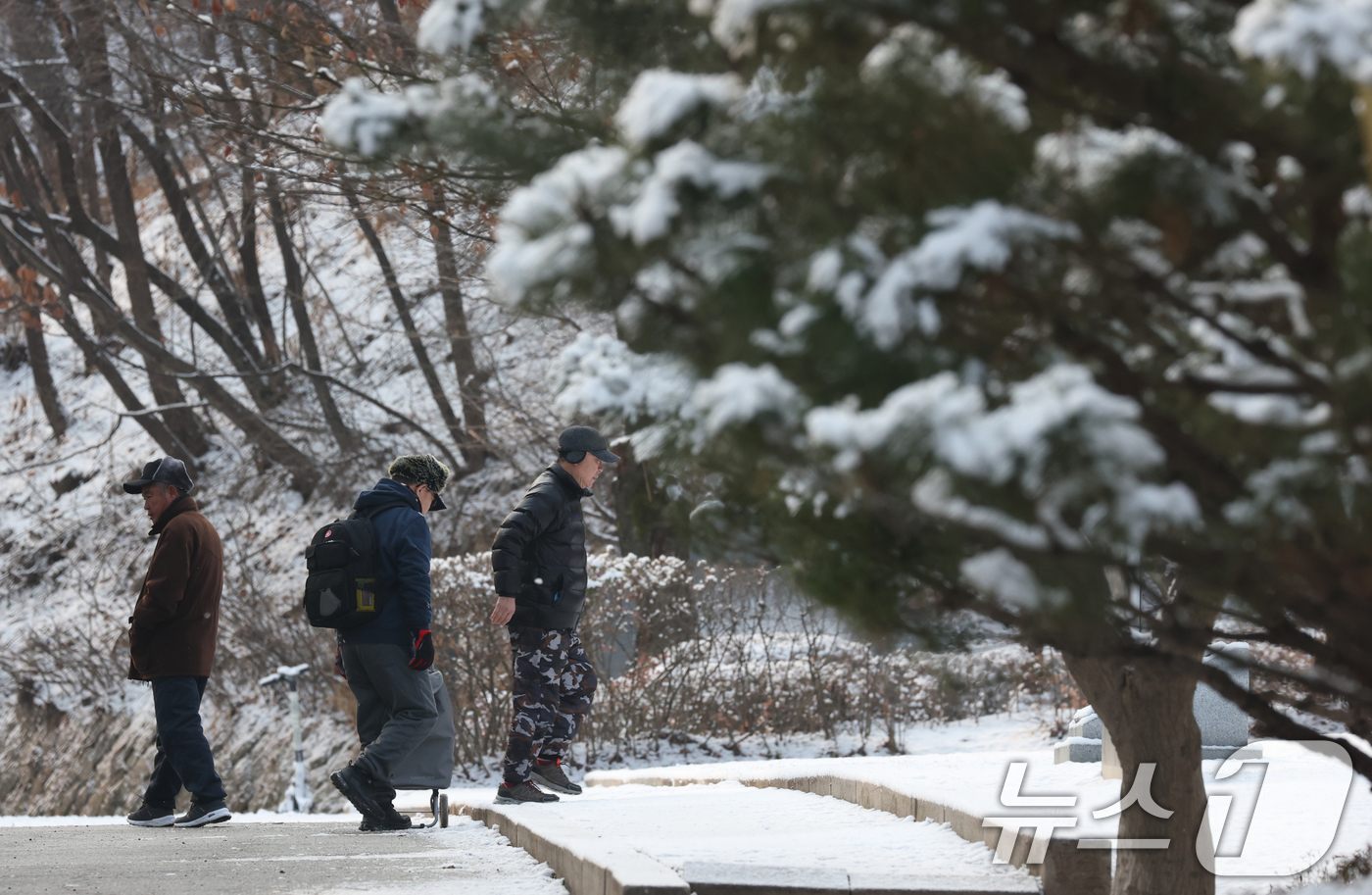 (수원=뉴스1) 김영운 기자 = 간밤에 눈이 내린 19일 경기 수원시 팔달구 팔달산 산책로에서 시민들이 산책을 하고 있다. 2026.1.19/뉴스1