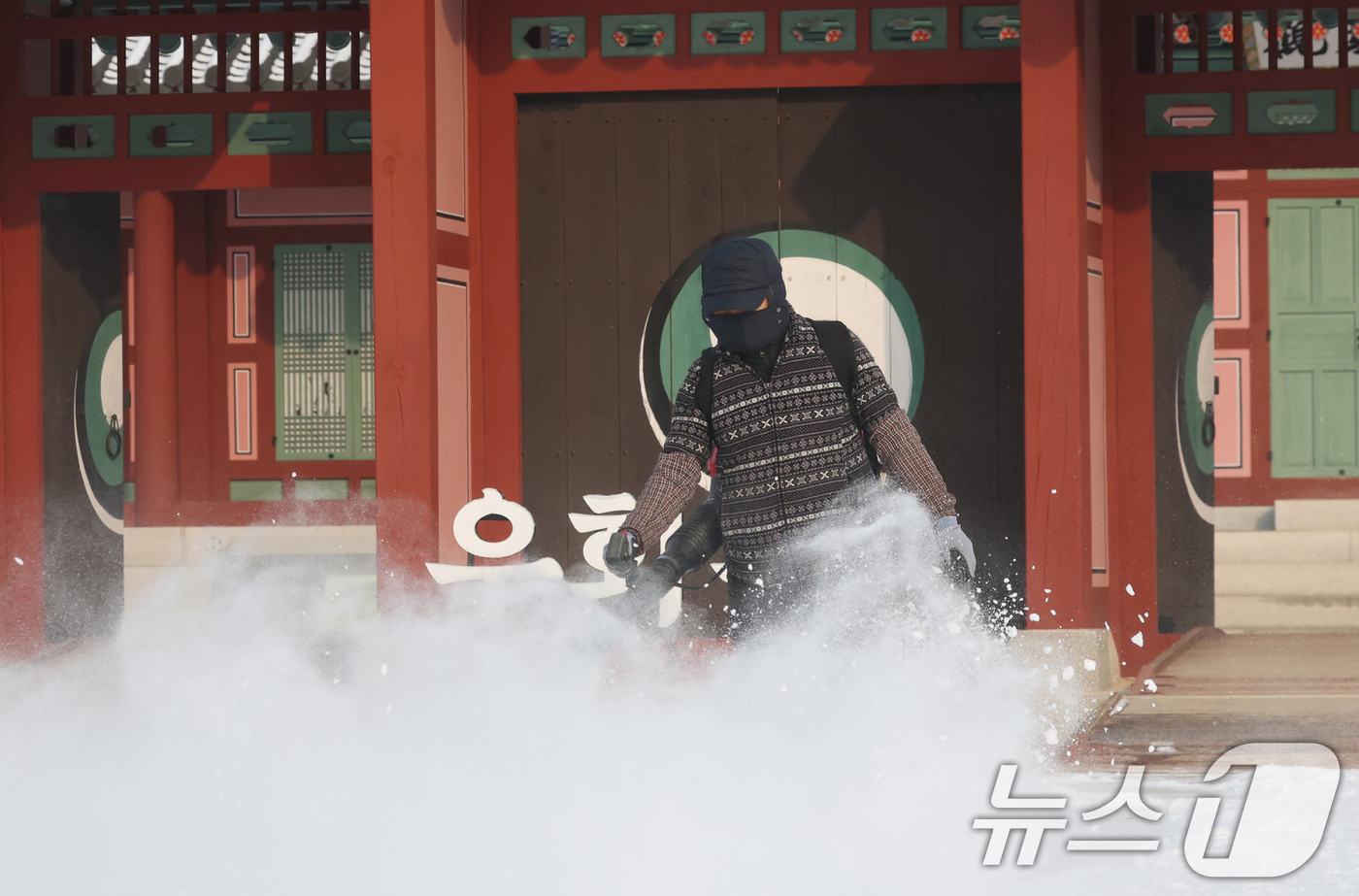(수원=뉴스1) 김영운 기자 = 간밤에 눈이 내린 19일 경기 수원시 팔달구 화성행궁에서 관계자가 제설작업을 하고 있다. 2026.1.19/뉴스1