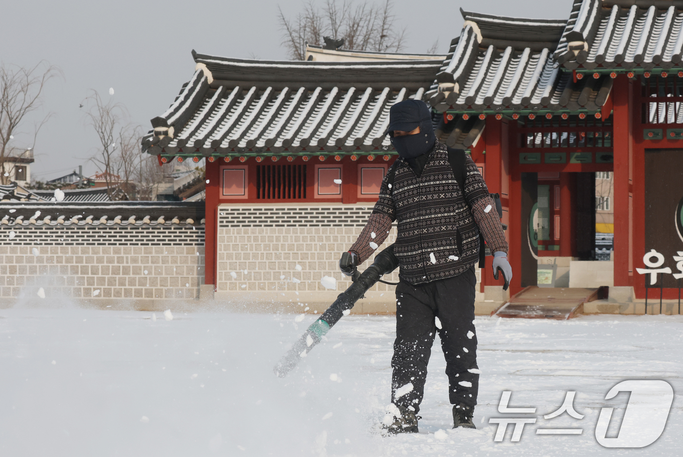 (수원=뉴스1) 김영운 기자 = 간밤에 눈이 내린 19일 경기 수원시 팔달구 화성행궁에서 관계자가 제설작업을 하고 있다. 2026.1.19/뉴스1