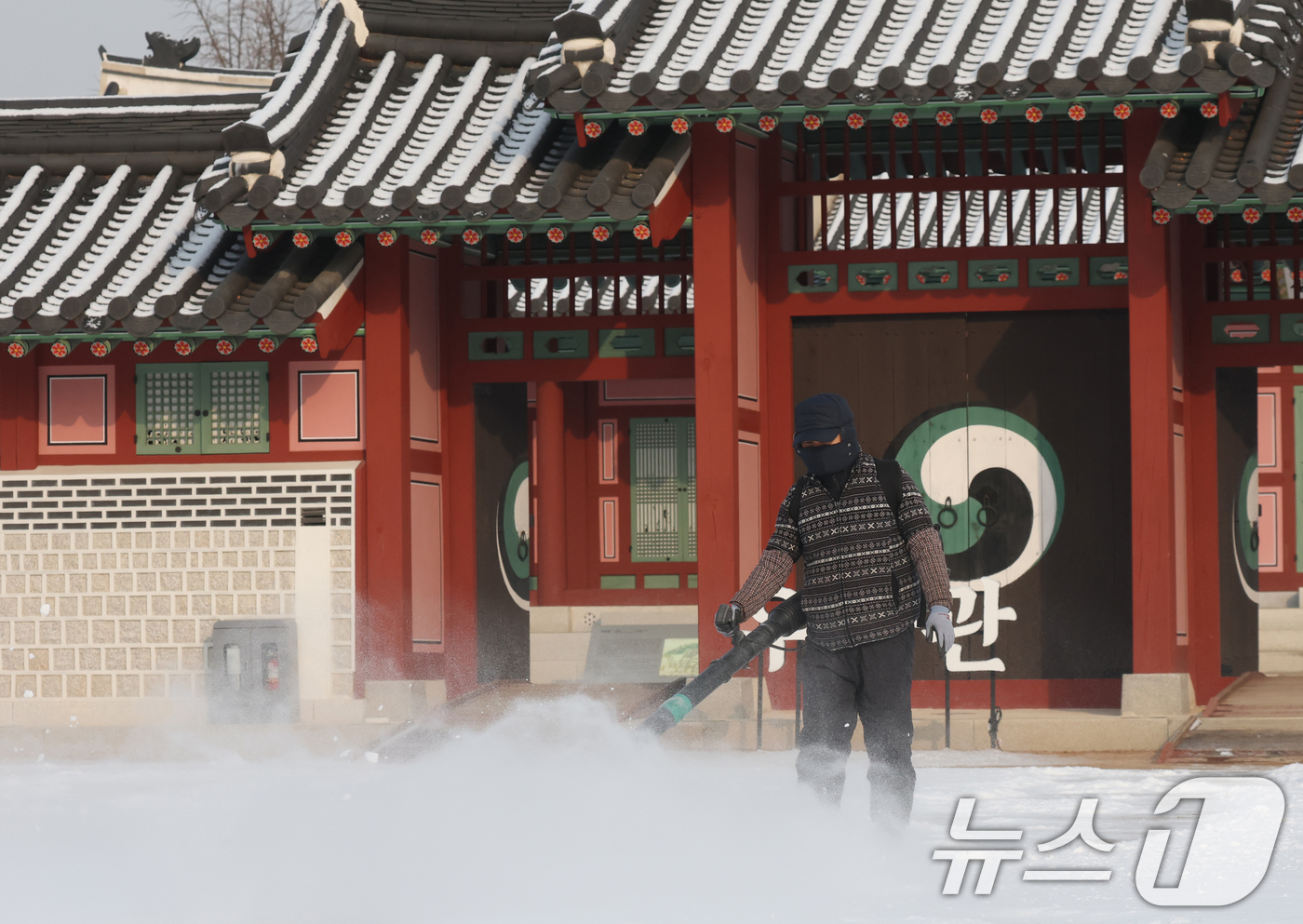 (수원=뉴스1) 김영운 기자 = 간밤에 눈이 내린 19일 경기 수원시 팔달구 화성행궁에서 관계자가 제설작업을 하고 있다. 2026.1.19/뉴스1