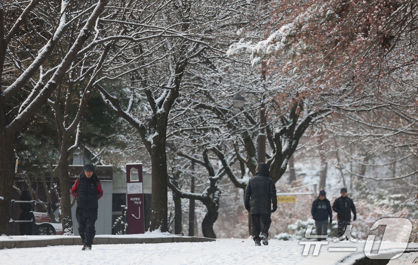 (수원=뉴스1) 김영운 기자 = 간밤에 눈이 내린 19일 경기 수원시 팔달구 팔달산 산책로에서 시민들이 산책을 하고 있다. 2026.1.19/뉴스1
