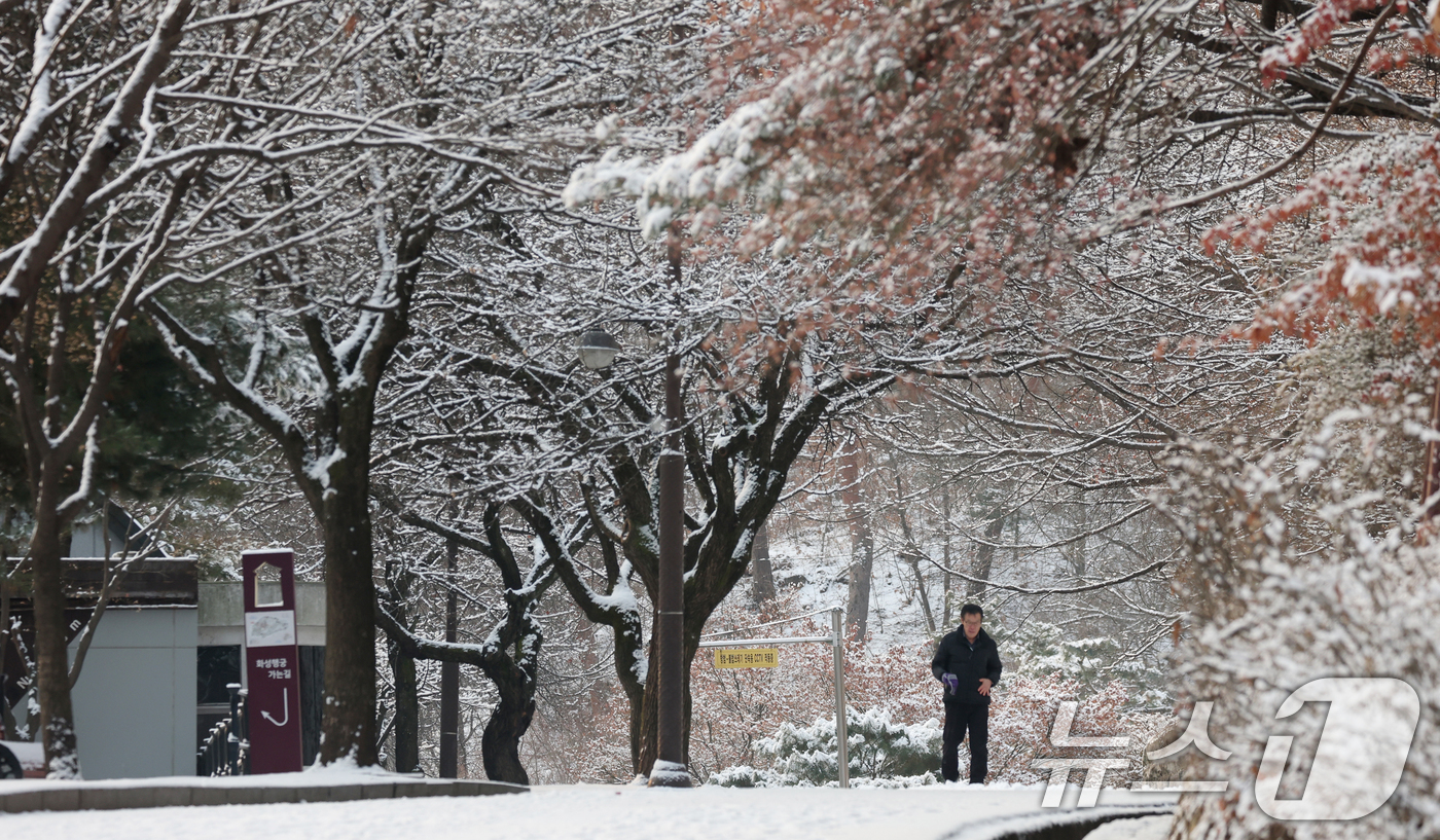 (수원=뉴스1) 김영운 기자 = 간밤에 눈이 내린 19일 경기 수원시 팔달구 팔달산 산책로에서 시민들이 산책을 하고 있다. 2026.1.19/뉴스1