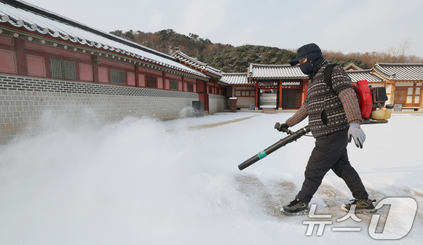 (수원=뉴스1) 김영운 기자 = 간밤에 눈이 내린 19일 경기 수원시 팔달구 화성행궁에서 관계자가 제설작업을 하고 있다. 2026.1.19/뉴스1