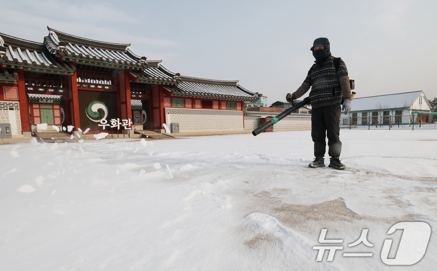 (수원=뉴스1) 김영운 기자 = 간밤에 눈이 내린 19일 경기 수원시 팔달구 화성행궁에서 관계자가 제설작업을 하고 있다. 2026.1.19/뉴스1
