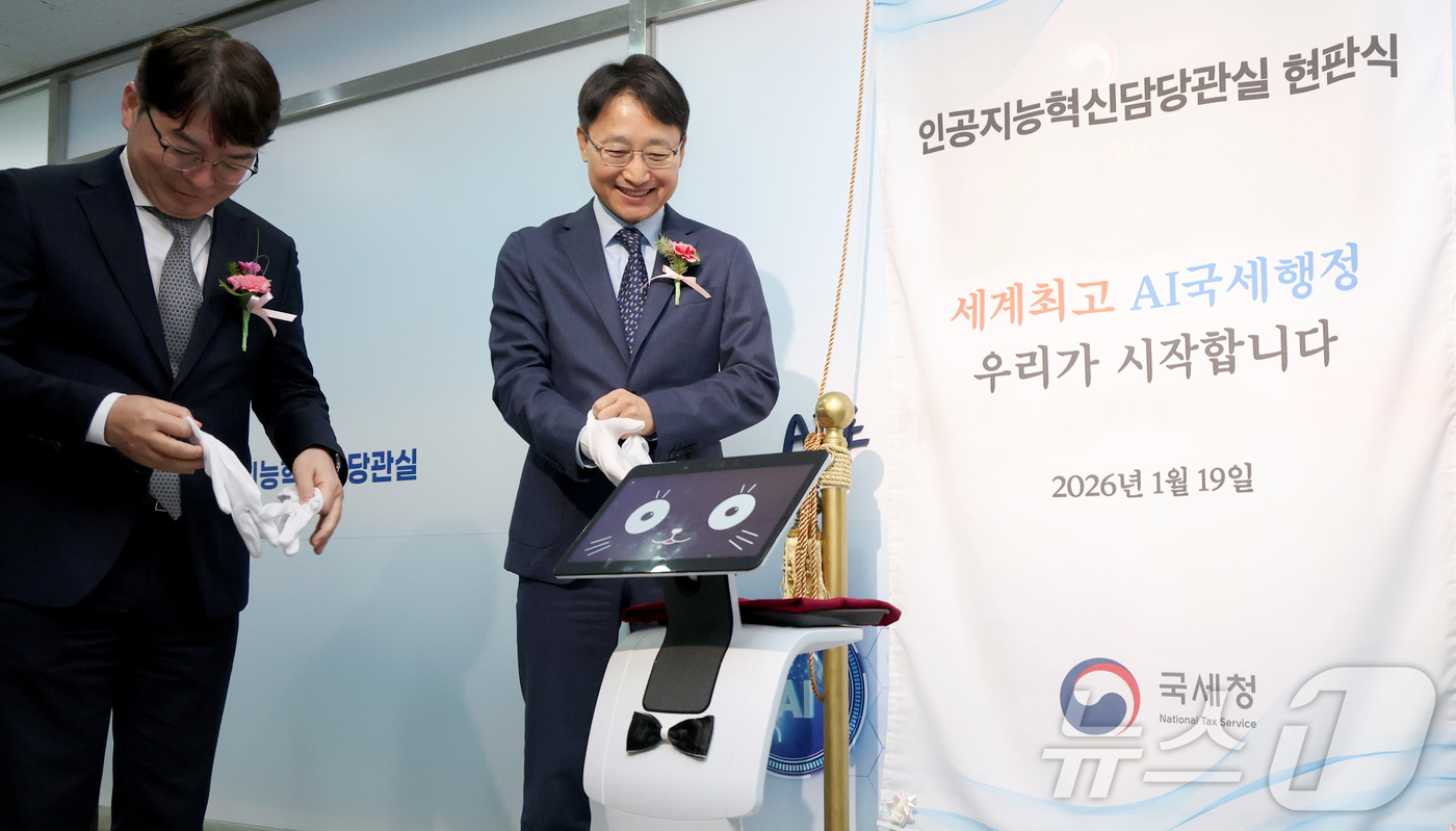 (세종=뉴스1) 김기남 기자 = 임광현 국세청장(왼쪽 두번째)이 19일 세종시 나성동 SM타워에 문을 연 AI혁신담당관실 현판식에 참석하여 로봇 카이(K-AI)에게 받은 장갑을 착 …