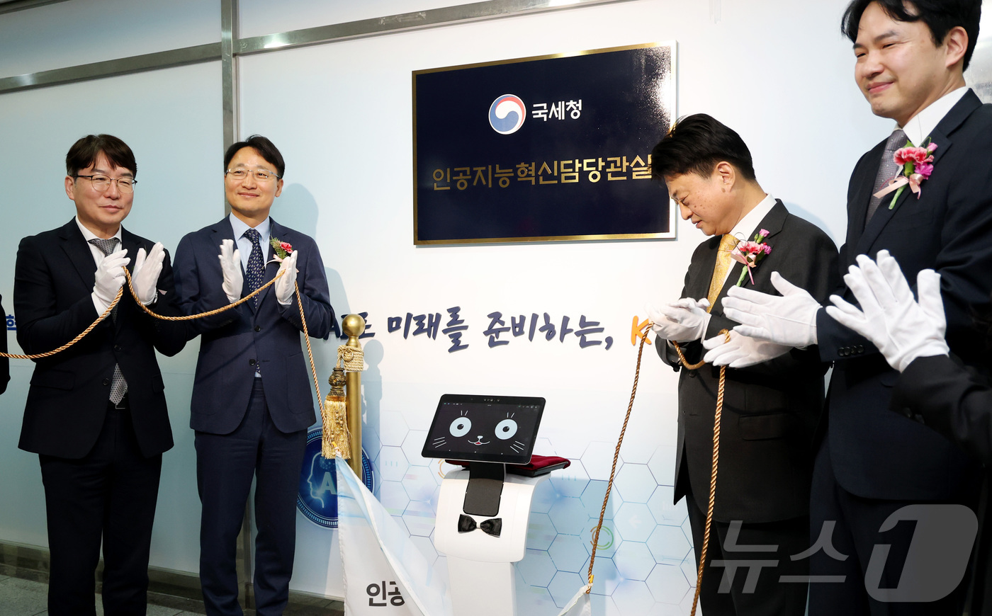 (세종=뉴스1) 김기남 기자 = 임광현 국세청장(왼쪽 두번째)이 19일 세종시 나성동 SM타워에 로봇 카이(K-AI) 및 관계자들과 AI혁신담당관실 현판식을 마친 뒤 AI 국세행정 …
