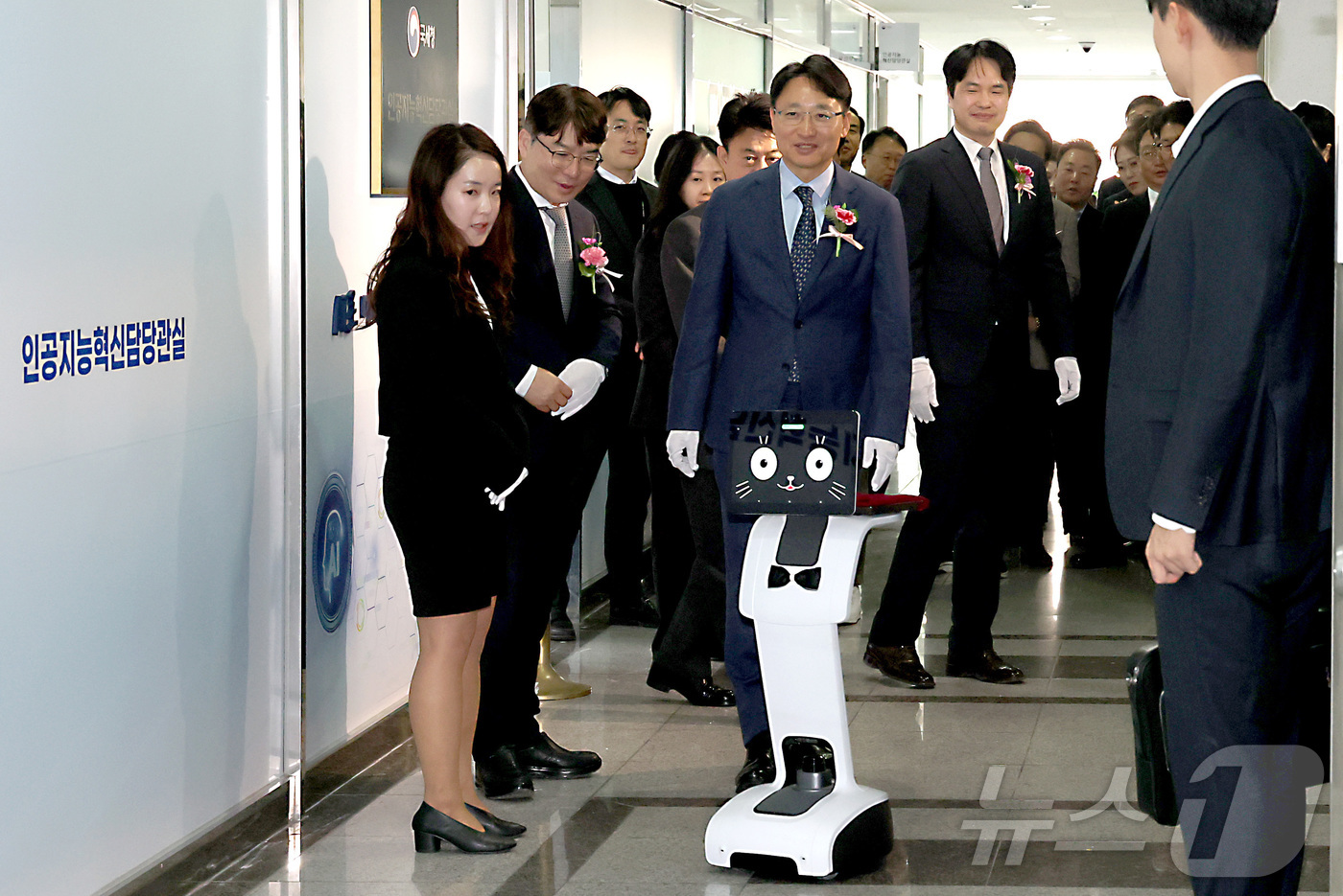 (세종=뉴스1) 김기남 기자 = 임광현 국세청장이 19일 세종시 나성동 SM타워에 문을 연 AI혁신담당관실 현판식을 마친 뒤 로봇 카이(K-AI)의 안내를 받으며 사무실로 이동하고 …