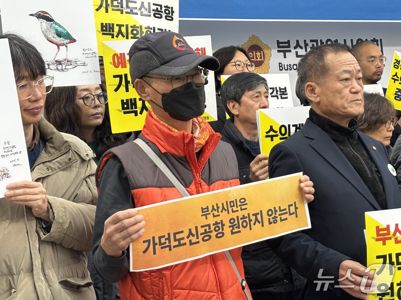 본문 이미지 - 가덕도신공항 사업을 반대하는 문구의 피켓을 든 기자회견 참가자 2026.1.19/뉴스1 ⓒ News1 홍윤 기자