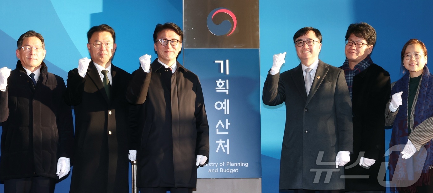 (세종=뉴스1) 김기남 기자 = 김민석 국무총리가 2일 오전 세종시 정부세종청사 6동에서 열린 기획예산처 출범 현판식에 참석하여 부처 관계자들과 현판 제막을 마친 뒤 화이팅을 외치 …