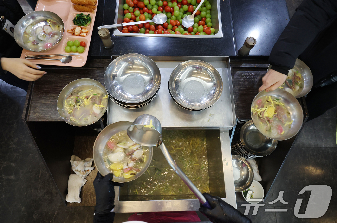 (수원=뉴스1) 김영운 기자 = 2일 경기 수원시 팔달구 수원시청 구내식당에서 2026년 병오년(丙午年) 새해를 맞아 조리실무사들이 떡국을 나눠주고 있다. 2026.1.2/뉴스1