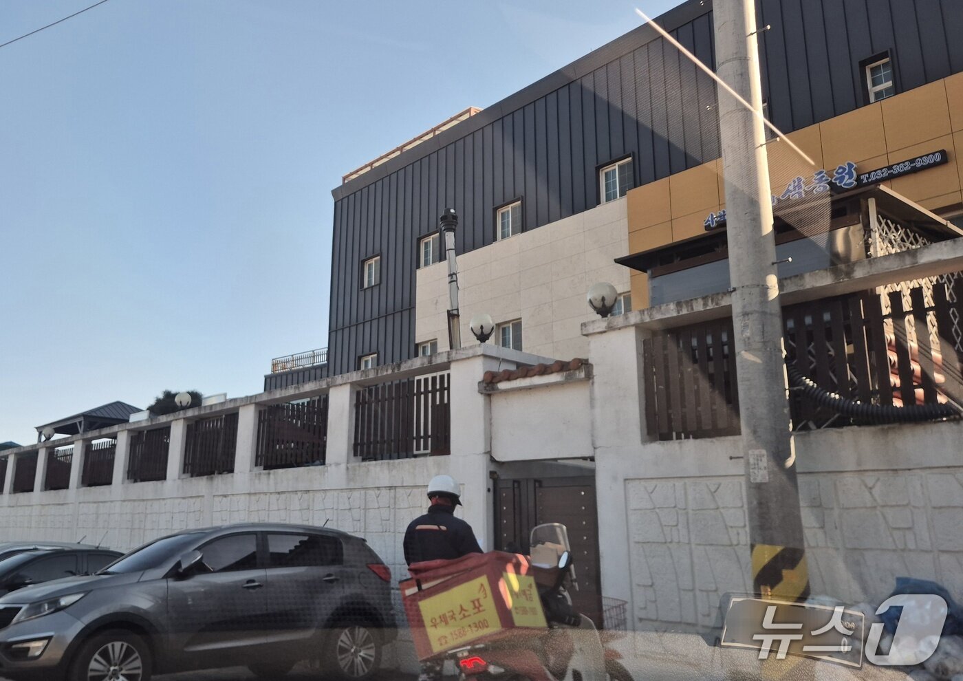 본문 이미지 - 20일 인천 강화군 중증장애인거주시설 색동원을 찾은 우체국 직원이 소포 전달을 위해 쪽문 앞에 서있다.이시명 기자/뉴스1