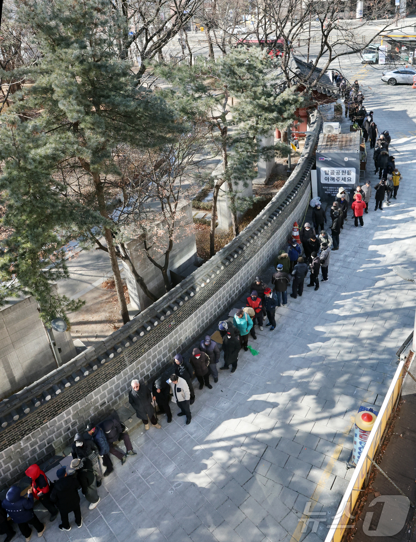 (서울=뉴스1) 김진환 기자 = 절기상 대한(大寒)이자 한파특보가 발효된 20일 서울 종로구 탑골공원 원각사 노인 무료급식소를 찾은 어르신들이 식사를 위해 줄을 서 있다. 2026 …